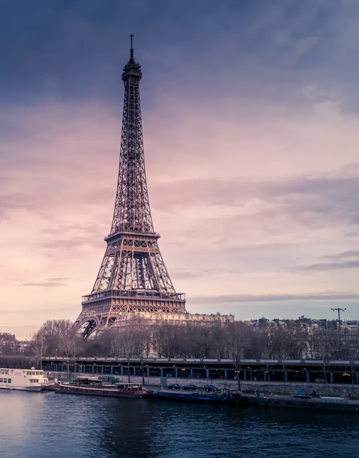 Torre Eiffel ao entardecer às margens do rio Sena
